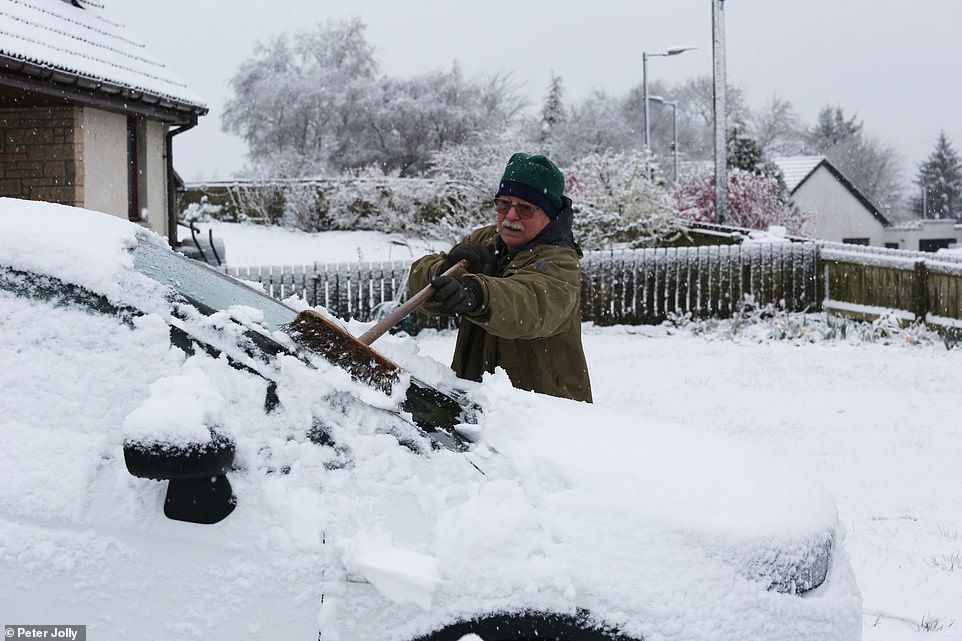 56238033-10687151-A_man_from_a_village_near_Inverness_clears_snow_from_his_car_thi-a-23_1649150232798.jpg